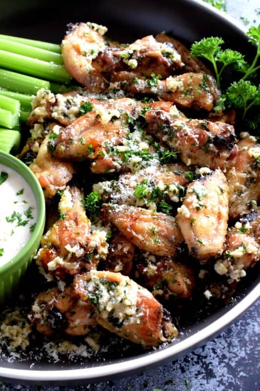 Chicken wings should be easy to prepare and taste great and those two simple rules are applied to these Garlic Parmesan Chicken Wings. With so much flavour, it's hard to believe that they are baked in an oven!  Tossed in a garlicky, cheesy, butter sauce, there never seems to be enough of these to please everyone! #garlic #garlicky #parmesan #cheese #chicken #wings #baked