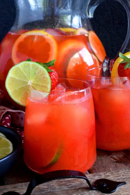 A refreshing summer drink made with simple syrup, whole strawberries, lime and lemon juice. If you're looking to up your lemonade game, this one is for you! Make a pitcher and serve with lots of ice on a hot summer day.  Turn leftover Strawberry Lime Lemonade into popsicles simply by pouring the juice into a popsicle mold and freezing! #limeade #strawberry #juice #lemonade #lime