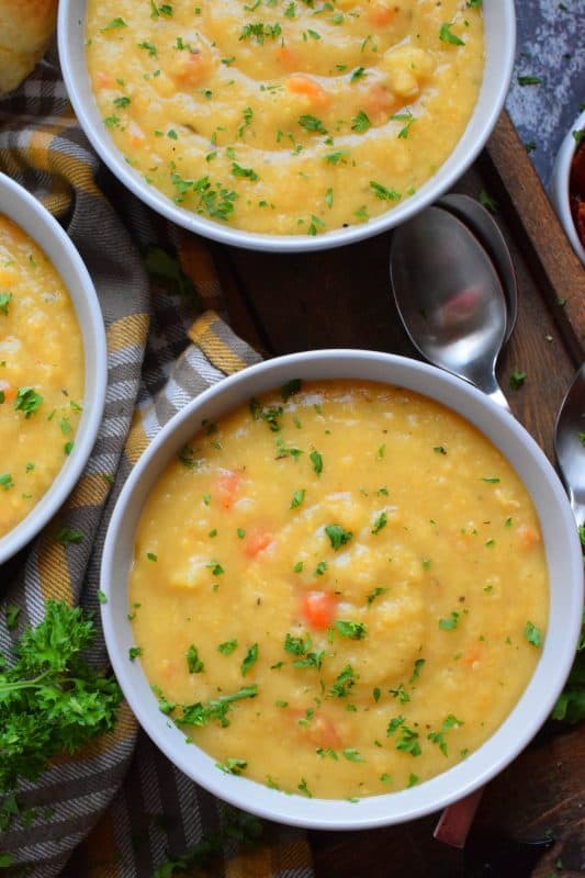 Vegetarian Split Pea Soup is every bit as delicious, wholesome, and nostalgic as the soup your mom made. This is a pantry staple recipe with a few fresh root vegetables. Not looking for vegetarian soup? Add bacon or ham to your soup or serve them both on the side! #soup #splitpea #split #pea #dried #yellow #dumplings #vegetarian