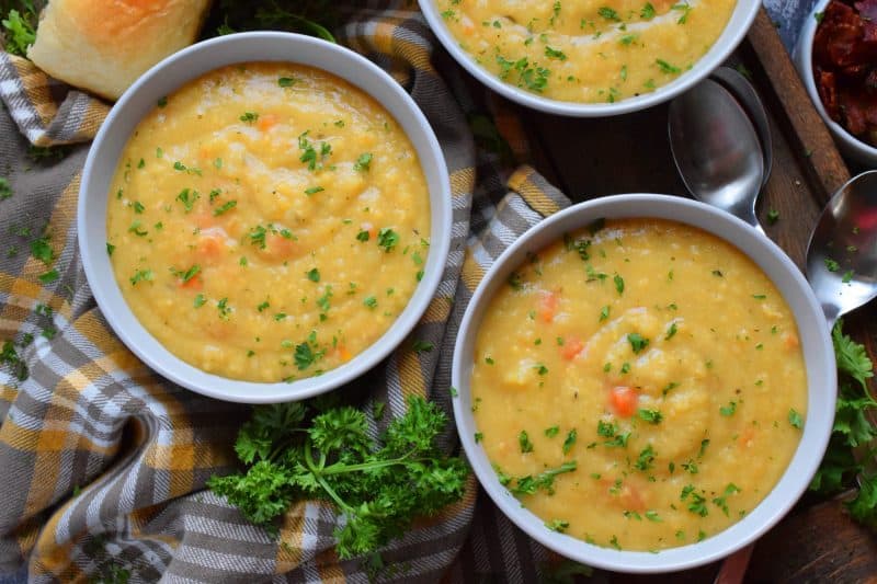 Vegetarian Split Pea Soup is every bit as delicious, wholesome, and nostalgic as the soup your mom made. This is a pantry staple recipe with a few fresh root vegetables. Not looking for vegetarian soup? Add bacon or ham to your soup or serve them both on the side! #soup #splitpea #split #pea #dried #yellow #dumplings #vegetarian