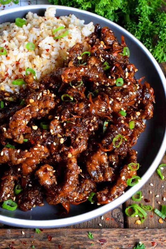 Thinly sliced beef, fried until crispy, and coated in a sweet and slightly spicy garlic and ginger sauce; 30 Minute Ginger Beef is an inexpensive dinner the whole family will love! #ginger #beef #takeout #homemade #garlic #fried #crispy