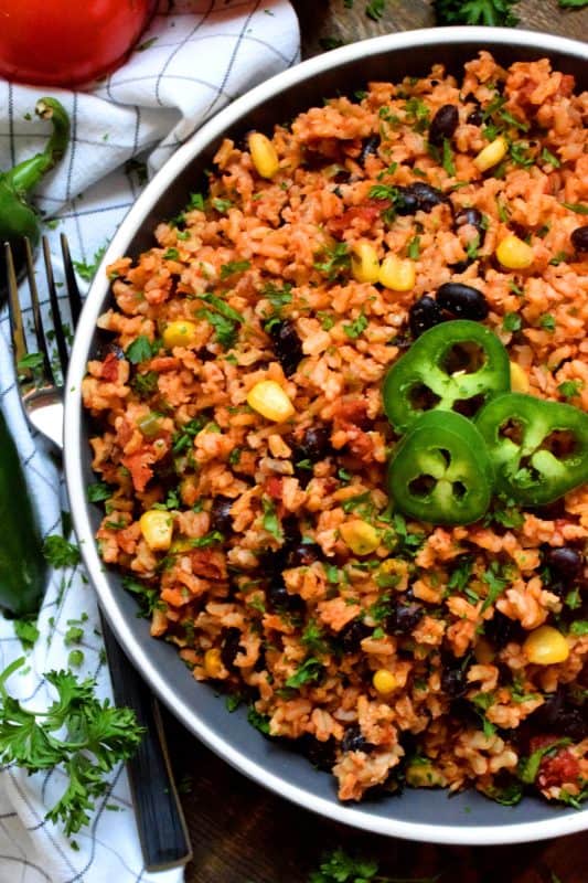 Toss everything into one pot, stir to combine, and let it go! That's just how easy it is to prepare this Mexican One Pot Instant Rice!  It's a delicious side served hot or at room temperature. Try it stuffed into a burrito with chicken, beef, or pork! #mexican #rice #instantrice #cornandbeans #side
