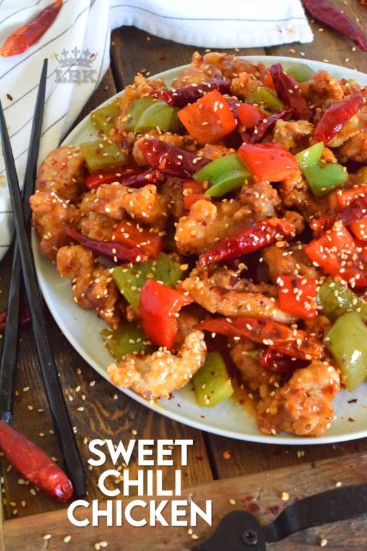 Sweet Chili Chicken is a prepared with a homemade sweet and spicy sauce, and tossed with red and green bell peppers. Use boneless, skinless chicken thighs and finish with toasted sesame seeds for best results. #sweet #heat #chili #sauce #chicken #takeout #asian #fried