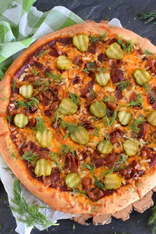 If you love a strong dill presence, you are going to devour this Bacon Dill Pickle Pizza! Prepared with a dill flavoured crust, and topped with fresh dill and dill pickles, this pizza is a dill lovers dream and then some! #dillpickle #bacon #pizza #homemadepizza #dillpicklepizza