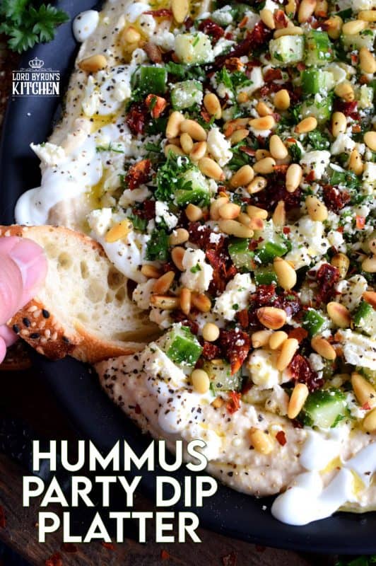 What's a party without dip? Hummus Party Dip Platter is a large, layered dip that's just perfect for entertaining a crowd. This all in one dip has hummus, sour cream, pine nuts, sun dried tomatoes, cucumbers, feta, and a few other ingredients too! #hummus #dip #partydip #partyfood #layereddip #hummusplatter #platter