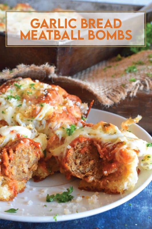 Garlic Bread Meatball Bombs are hollowed out dinner rolls which have been liberally smeared with homemade garlic butter. Each roll is stuffed with a meatball and sauce, then topped with cheese. Baked to a bubbling, gooey perfection, these bombs are the bomb! #meatballs #sliders #dinnerrollrecipes #bombs #meatballrecipes #familyrecipes #garlicbread