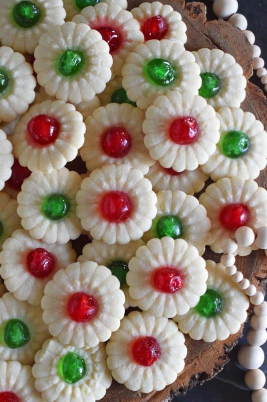 A good spritz cookie should taste slightly sweet and buttery. The cookie should be slightly crumbly, but not dry, and it should melt on your tongue. Nothing is more Christmassy than Cherry Spritz Cookies! It's a long-standing holiday favourite and this one screams cheerful with those brightly coloured candied cherries! #candiedcherries #spritz #spritzcookies #baking #christmas #holiday #redandgreen