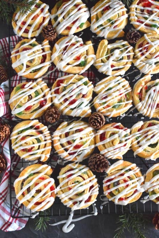 One of my favourite Christmas ingredients is being put to great use today! Cherry Pinwheel Cookies are made with a light, biscuit-like dough and rolled with red and green candied cherries. Drizzled with a basic sweet icing, these are absolutely delicious and very festive too! #christmas #holiday #baking #cherries #candiedcherries #cherry #redandgreen #drizzle