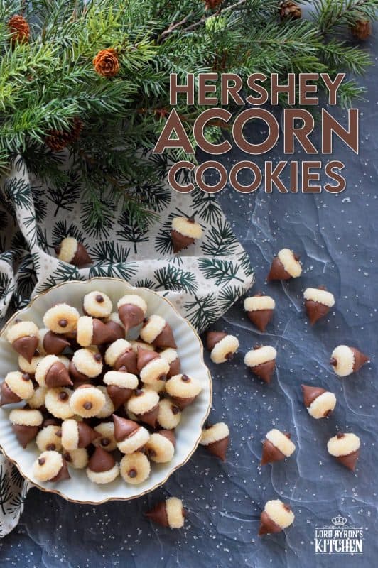 These adorable bite-sized cookies are bound to be a complete hit! They look stunning all on their own, but are perfect for filling in the gaps on your Christmas cookie platter. Hershey Acorn Cookies are prepared with a miniature homemade cookie, and paired with a chocolate kiss and a single chocolate chip! #christmas #holiday #baking #acorn #hershey #kiss #cookies
