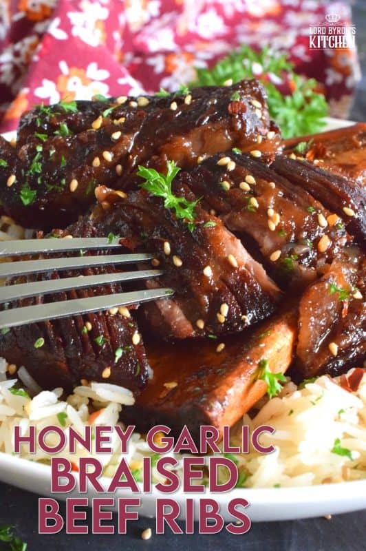 Pan-seared beef ribs are braised in a honey garlic sauce prepared with red wine. These moist and tender ribs are perfect for a cold winter night's dinner. Serve with hearty polenta or mashed potatoes and be sure to ladle on some of that thick, glossy, sweet, and garlicky sauce! #beef #beefribs #shortribs #honeygarlic #dutchoven #braised