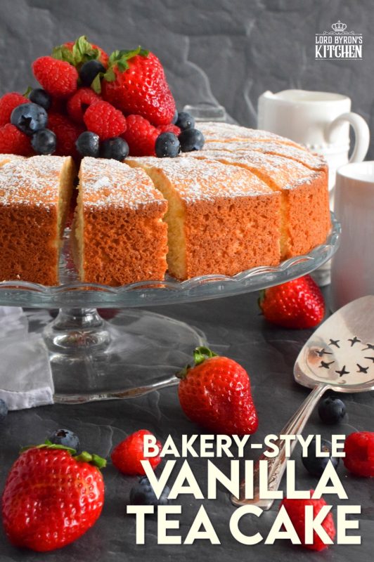 This Bakery Style Vanilla Tea Cake looks superb gussied up with a dusting of confectioner's sugar and a pile of fresh berries. A delightful treat anytime, this cake is the epitome of a beautiful, yet simple, summertime dessert! Bake, slice, and serve with ice cream or whipped cream! #vanillacake #teacake #teatime #bakery 