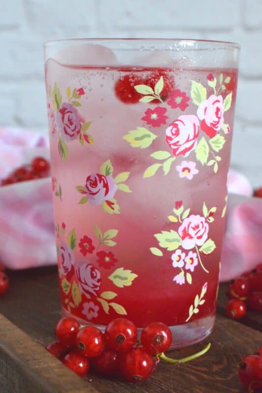 Cold, sweet, sparkling, and fizzy; this Red Currant Refresher starts with a red currant infused simple syrup and is stirred into lemon lime pop with lots of ice. Eat your heart out, Starbucks! Summer never tasted so good! #red #currant #redcurrants #currants #summer #drink #refresher