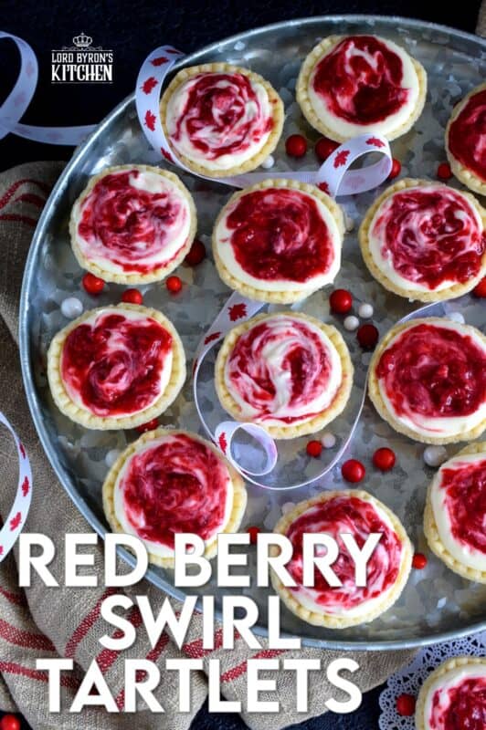 An easy to assemble treat perfect for any Canada Day celebration. Red Berry Swirl Tartlets are flaky, buttery, creamy, and sweet. Buy store-bought frozen tart shells to make this recipe fast and easier.  These are stuffed with a cream cheese filling and a red berry compote! #canadaday #recipes #redandwhite #tarts #berry #red