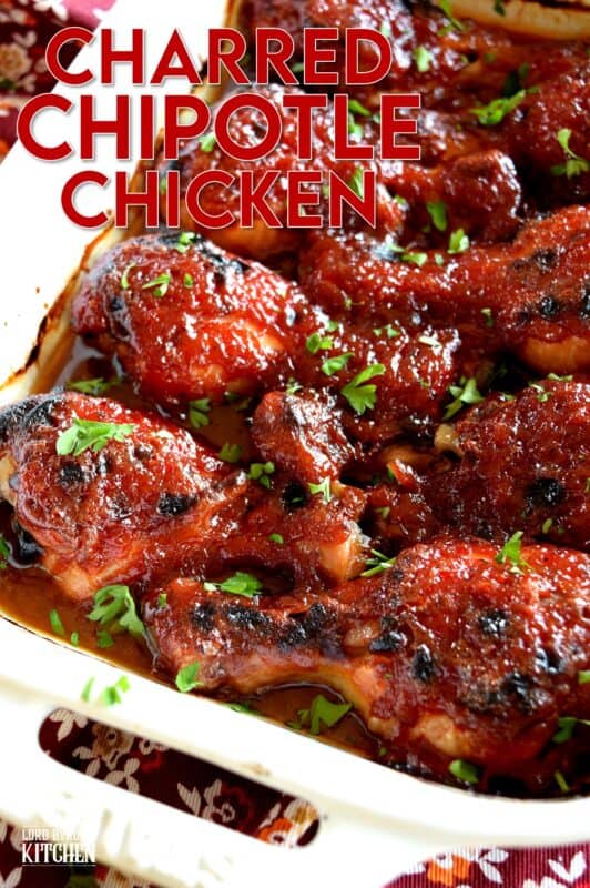 In this Charred Chipotle Chicken recipe, inexpensive drumsticks are baked with onion and then topped with a thick, sweet sauce consisting of chipotle peppers in adobo sauce, vinegar, brown sugar, and more.  This is certainly an easily family pleasing main! #bakedchicken #drumsticks #spicychicken #chipotle #adobosauce #saucy