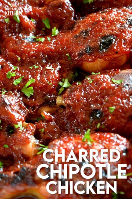 In this Charred Chipotle Chicken recipe, inexpensive drumsticks are baked with onion and then topped with a thick, sweet sauce consisting of chipotle peppers in adobo sauce, vinegar, brown sugar, and more.  This is certainly an easily family pleasing main! #bakedchicken #drumsticks #spicychicken #chipotle #adobosauce #saucy