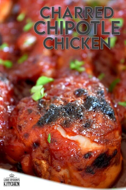 In this Charred Chipotle Chicken recipe, inexpensive drumsticks are baked with onion and then topped with a thick, sweet sauce consisting of chipotle peppers in adobo sauce, vinegar, brown sugar, and more.  This is certainly an easily family pleasing main! #bakedchicken #drumsticks #spicychicken #chipotle #adobosauce #saucy