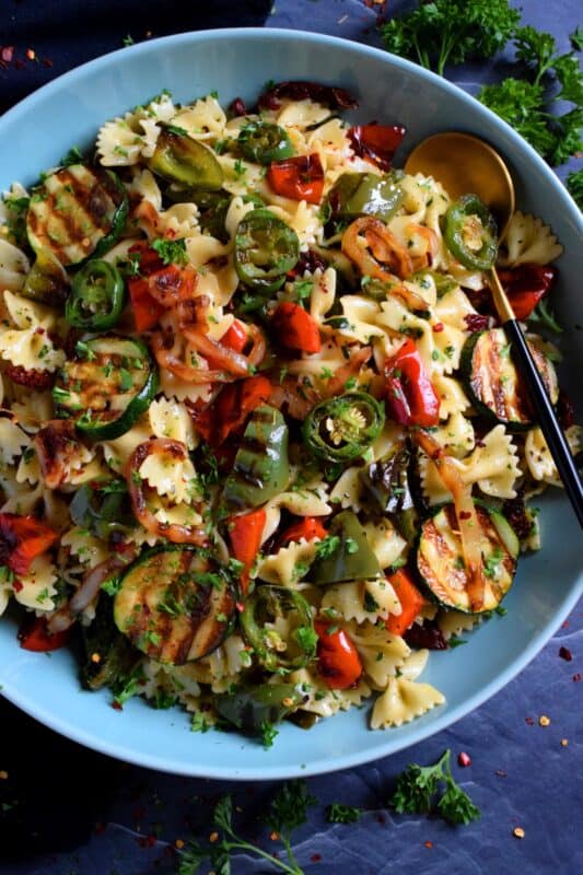 Perfectly charred bell peppers, onions, jalapenos, and zucchini make up this Grilled Vegetable Pasta Salad. Tossed with a simple, easy to make, light, oil-based homemade dressing, this is a perfect summer side! Serve warm or at room temperature! #grilled #vegetable #veggies #pasta #salad #summer #side #picnic #backyard