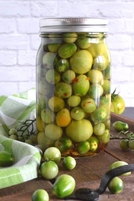 At the end of growing season, just before the first frost, harvest the last of those unripened cherry tomatoes and make a batch of Pickled Green Tomatoes! It's a shame to let them go to waste when you can make something so delicious in just a few minutes! #pickled #tomatoes #quickpickle #greentomatoes