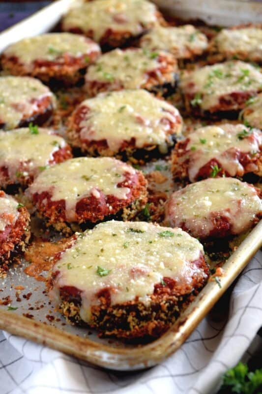 An update on an old Italian classic; this healthier version of Sheet Pan Eggplant Parmesan is bursting with flavour.  No need to pan-fry the eggplant first in this version; it's coated in panko crumbs and baked to keep it crispier and lighter! #eggplant #parmesan #eggplantparmesan #italianrecipes #sheetpan #sheetpanrecipes #eggplant #parmesan #eggplantparmesan #italianrecipes #sheetpan #sheetpanrecipes
