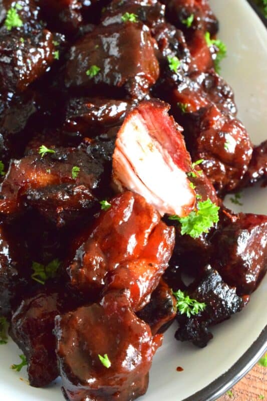 Barbecued Smoked Pork Belly Burnt Ends are prepared with trimmed and cubed pork belly which has been dry rubbed with a sweet spice blend. The pork is smoked with apple wood before being tossed with sauce and returned to the smoker to char up. #porkbelly #smoked #smoker #smokedrecipes #bbq #smokedpork #burntends
