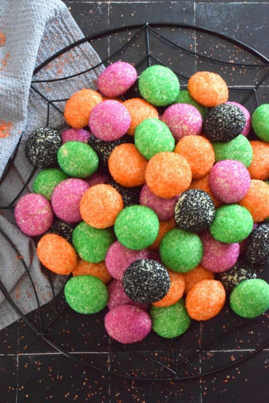 Just in time for the little trick-or-treaters in your life, these melt-in-your-mouth orange, green, purple, and black cookies are about to become everyone's favourite Halloween treat! Sugared Halloween Cookies are made with just five ingredients, and they're quick and easy too! #halloween #cookies #sugar #sanding #orangeandblack