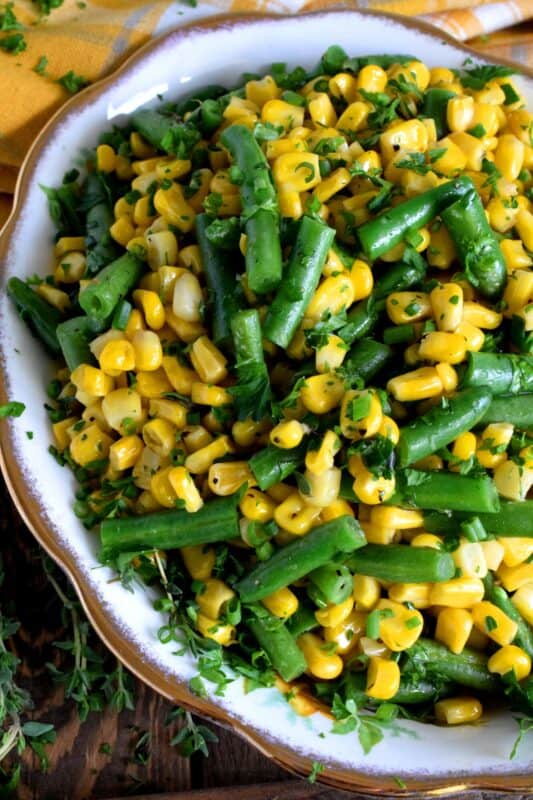 Herb Buttered Corn and Green Beans is a rustic, delicious, family-pleasing vegetable side dish. The fresh herbs make this dish fresh and flavourful, but let's face it, everything sautéed in butter is better! This inexpensive side is perfect for any family dinner, yet, special enough for Thanksgiving too! #corn #greenbeans #vegetarian #sidedish