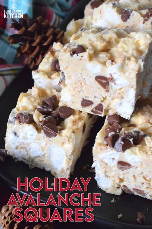 These no-bake treats are prepared with lots of white chocolate, creamy peanut butter, a few cups of rice cereal, and a good helping of marshmallows too.  Holiday Avalanche Squares are absolutely delicious!  The white chocolate is melted together with the peanut butter, and once cooled, the other ingredients are folded in to create these wonderfully high and cloudy-soft squares! #squares #bars #nobake #christmas #holiday #baking #cookies #chocolate