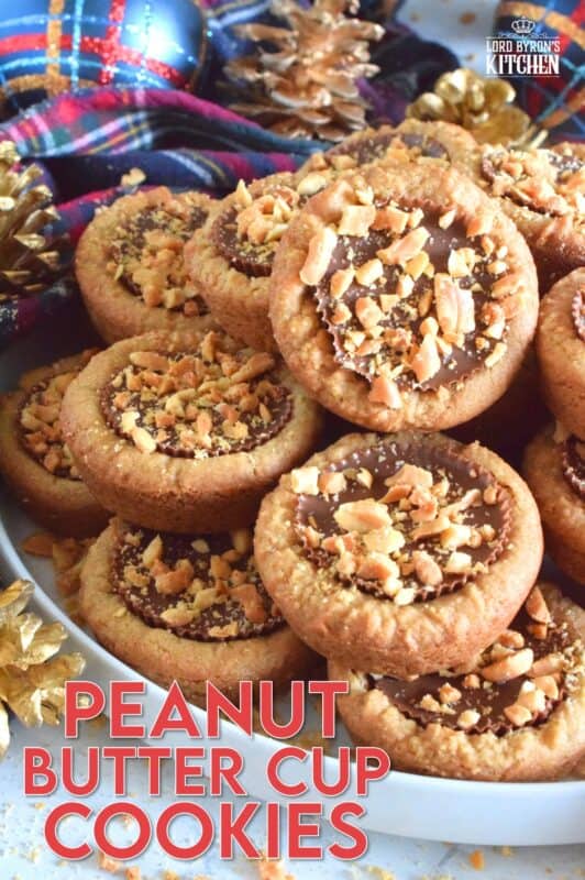 Thumbprint-style cookies are very popular at Christmastime, so why not over-stuff them with a full-sized Peanut Butter Cup?  These cookies are so easy to make and are baked in muffin tins!  Push in the peanut butter cup and top with chopped peanuts for more texture and flavour! #peanutbutter #reeses #cookies #thumbprint