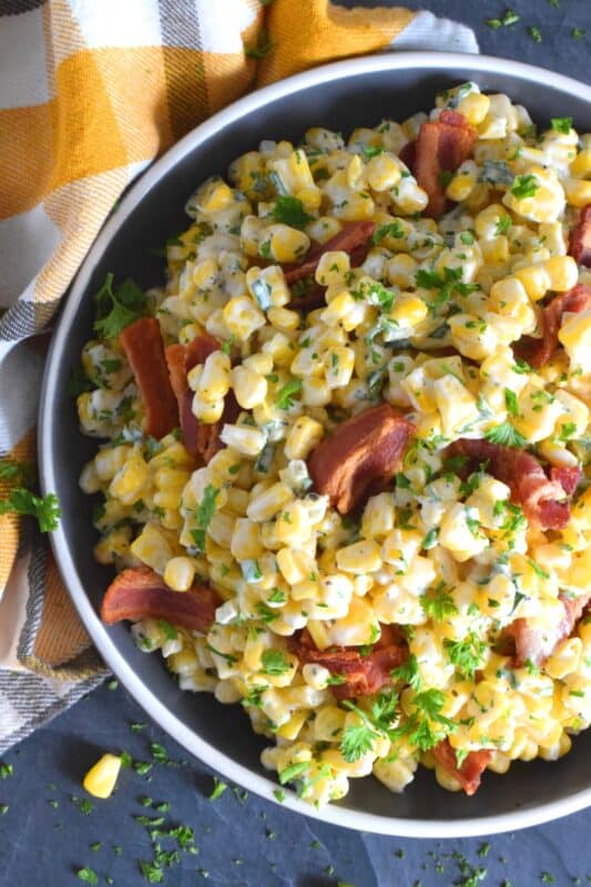 Serve this Bacon and Corn Salad warm as a side to your favourite summer grilled mains.  Loaded with fried bacon, bright yellow corn, and fresh green onions, this salad is tossed with a kicked-up mayonnaise-based dressing.  Can be prepared ahead of time too and just lightly reheated through just before serving! #bacon #corn #salad