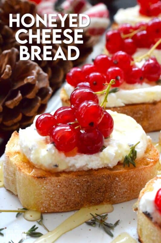 Toast or grill thinly sliced bread and top it with whipped goat cheese.  Drizzle over your favourite honey and garnish with fresh thyme leaves and berries.  Honeyed Cheese Bread is sweet and salty and is completely irresistible.  The creaminess of the cheese and honey is a great match for the chewiness of the toasted baguette. #honey #bread #appetizer #christmas #holiday
