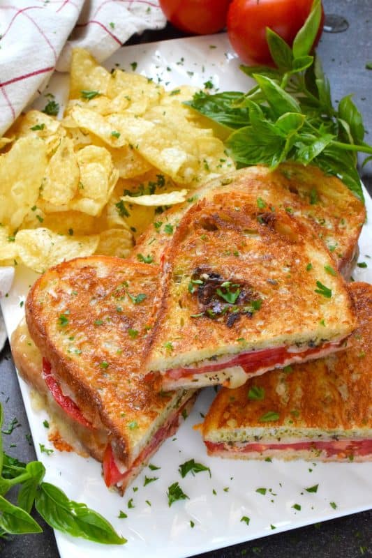 One of the most comforting and nostalgic childhood favourites is a grilled cheese sandwich paired with tomato soup. Nobody wants to eat soup in the summer, so my Tomato Grilled Cheese Sandwich is perfect! Summer fresh tomatoes and basil pesto are tucked into the sandwich to make the ultimate flavour combination!