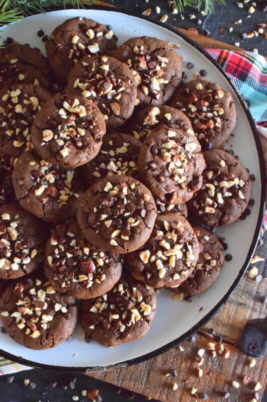 These cookies are slightly crispy on the outside, but with a moist and dense chocolaty center. Loaded with lots of chocolate chips and hazelnuts, Chocolate Hazelnut Cookies taste very much like eating a big spoon of Nutella in cookie form! #chocolatecookies #hazelnut #christmas #holiday #baking