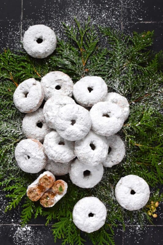 Packed full of red and green candied cherries and chopped toasted walnuts, these Walnut Cherry Donuts are the epitome of holiday-themed donuts!  Baked with familiar Christmas spices, this donut is very similar in flavour to fruitcake - but without the fuss! #walnut #candied #cherries #donuts