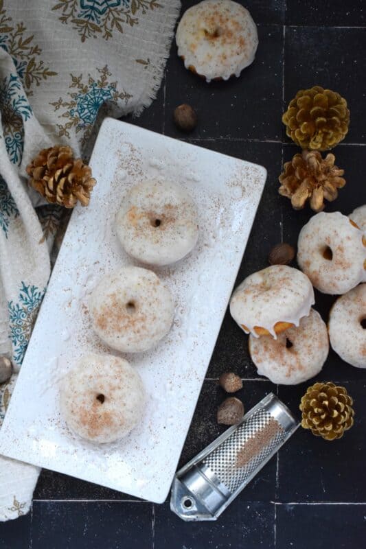 These Glazed Eggnog Donuts are baked and not fried, which means they are super light and fluffy.  Eggnog is baked right into the batter and the glaze is made with eggnog too, ensuring that this donut lives up to its name!  Optionally, this recipe permits a splash or rum or an alcohol-free version too! #donuts #doughnuts #eggnog #christmas #baked