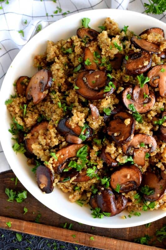 Garlicky Mushroom Quinoa is a rustic and simple side dish, but hearty enough to be a cozy main too! Prepared with meaty cremini mushrooms which have been pan-fried in lots of garlic and butter, this dish is both garlicky and savoury. #quinoa #mushrooms #cremini #side #salad