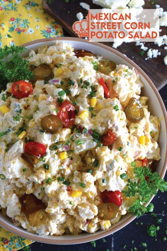 Chopped potatoes are tossed with sweet corn, spicy jalapenos, boiled eggs, fresh green and red onions, and salty cotija cheese to create this most delicious Mexican Street Corn Potato Salad! With its creamy, zingy, and tart dressing, this potato salad will most definitely be the most popular side at any backyard barbecue this summer! #salad #potato #streetcorn #mexican #cotija
