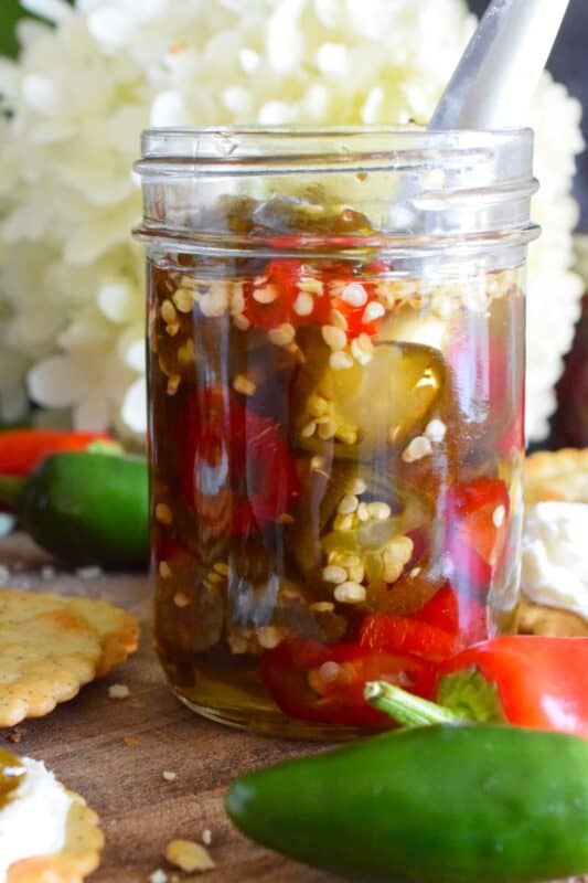 There are several types of canned jalapeno recipes that use up my summer jalapeno harvest, but Canned Cowboy Candy is my favourite! The jalapenos are boiled in a thick syrupy brine to draw out much of the moisture which results in a slighty chewy, sweet and spicy, delicously addicting candy-like treat that tastes great on just about everything! #canned #preserved #jalapeno #jalapenos #cowboy #candy