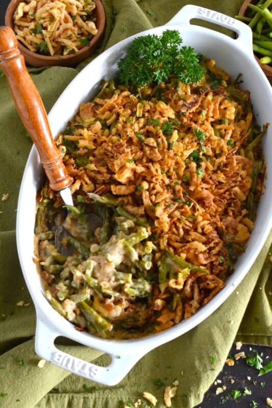 Unlike most Green Bean Casseroles which use canned green beans, this version uses fresh green beans and the results are incredible! In classic fashion, the tender beans are tossed with cream of mushroom soup, milk, and seasonings.  Baked with fried onions, this casserole also offers the option of adding shredded cheddar cheese! #casserole #beans #greenbeans #side #thanksgiving