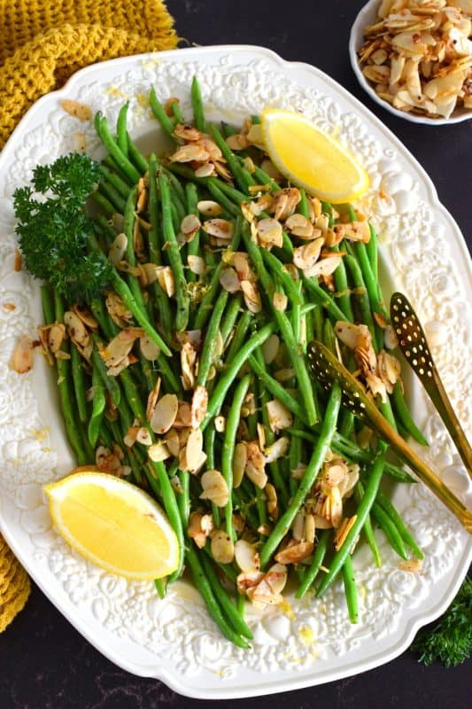 A quick and easy side perfect any time of the year, but in our home, green beans are always a popular side for thanksgiving. Paired with garlic, almonds, and lemon, Green Bean Almondine is a classic! #greenbeans #beans #almondine #thanksgiving #vegetable #side