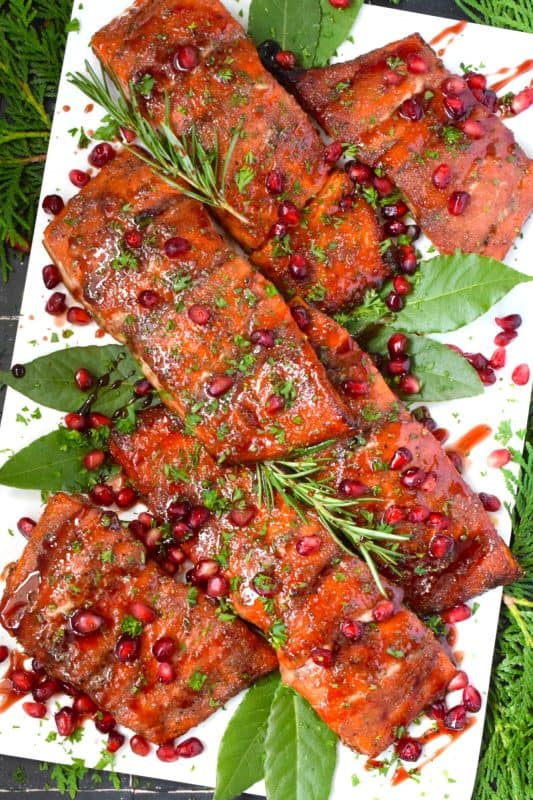 Salmon is often overlooked when it comes to a holiday main, but if you do it right, it can easily replace the overwhelmingly large and daunting task of roasting an entire turkey.  My Glazed Holiday Salmon is smothered with a savoury tart and tangy pomegranate molasses and topped with fresh pomegranate arils! #salmon #holiday #main #seafood #glazed #pomegranate #molasses