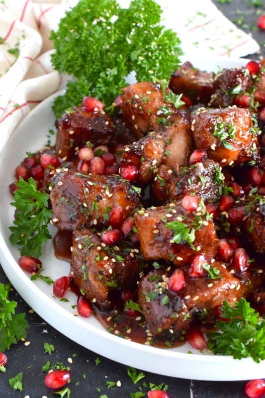 Marinated and flavoured with simple seasonings and sauces found in most kitchens, this Roasted Pomegranate Pork Belly is baked until moist and tender and then tossed in a honey and pomegranate molasses sauce, making this main easy to prepare for the holidays! #roasted #pork #porkbelly #pomegranate #holidays #molasses