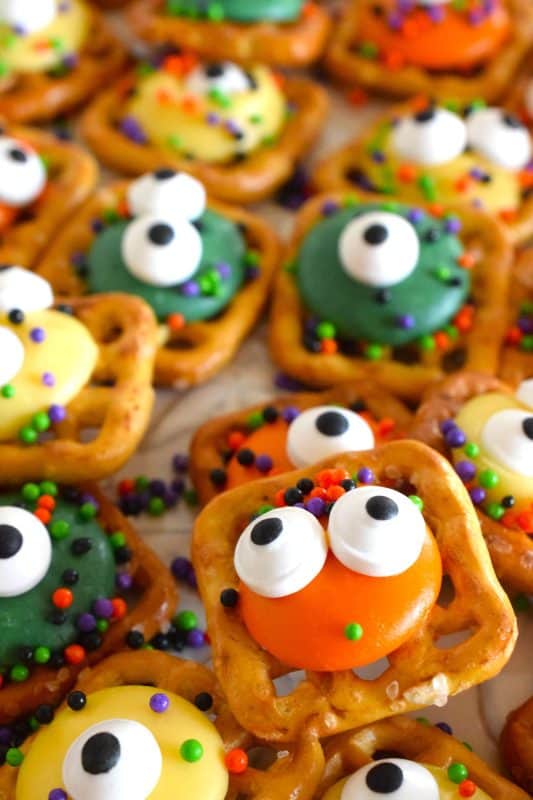 Usually, these types of snacks are prepared with a chocolate center, but to keep these Monster Eye Pretzel Snack Bites as halloween-like as possible, use a combination of yellow, green, and orange candy melt wafers instead! Top them with a candy eyes and halloween-themed sprinkles! Not only are they super cute, but they’re also super delicious! #monster #halloween #nobake #candy #pretzel #snack