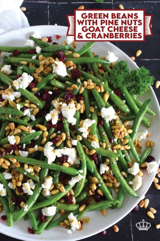 This delicious side dish prepared with green beans, toasted pine nuts, crumbled goat cheese, and dried cranberries takes only fifteen minutes in a skillet on your stovetop! How's that for a quick and easy holiday side?  Perfectly seasoned and quickly sauteed in butter, these green beans are delectably savoury! #greenbeans #cheese #pinenuts #thanksgiving #side
