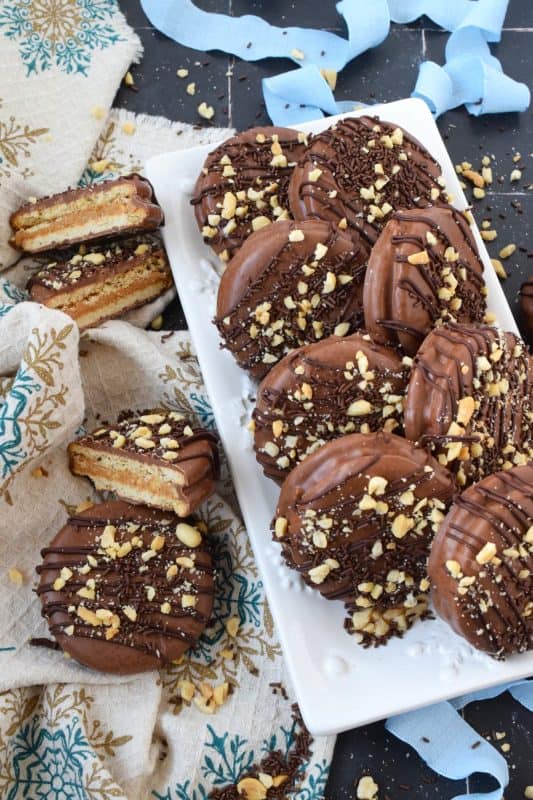 Peanut Butter Sandwich Cookies are a no-bake confection that uses ready-made store-bought ingredients to create the most deliciously indulgent snack! Use your favourite cookie or cracker such as digestive, ritz, or one that pairs well with peanuts, peanut butter, and melted milk chocolate! #peanut #peanutbutter #sandwich #cookies #nobake #chocolate