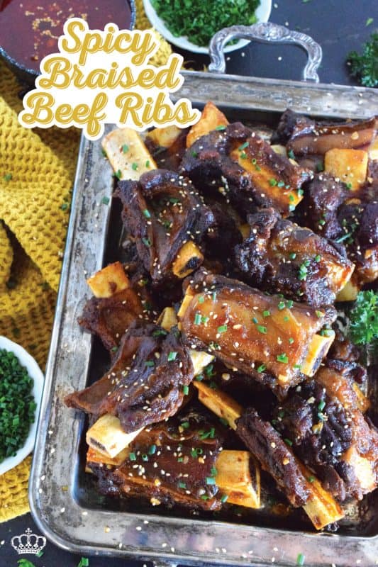 Beef ribs are braised in a sweet and sticky sauce prepared with red pepper paste and chilies. These moist and tender ribs are perfect for a cold winter night’s dinner!  Using easy to find Asian ingredients, these Spicy Braised Beef Ribs are easy to prepare and are simmered until the meat is practically falling off the bone! #beef #beefribs #spicy #braised