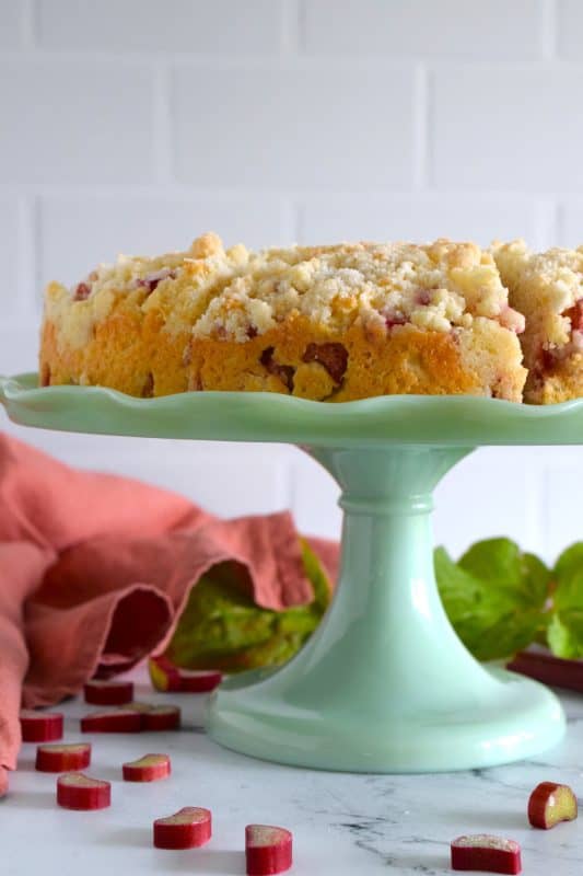 With two whole cups of chopped rhubarb and a good amount of lemon zest, this Rhubarb Coffee Cake tastes tangy, sweet, and very refreshing. With a sweet walnut crumb topping, this is one cake that should be served with a hot tea or coffee. Perfect served with whipped cream for dessert, as an afternoon snack, or for a fancy brunch too! #rhubarb #fresh #coffeecake #cake