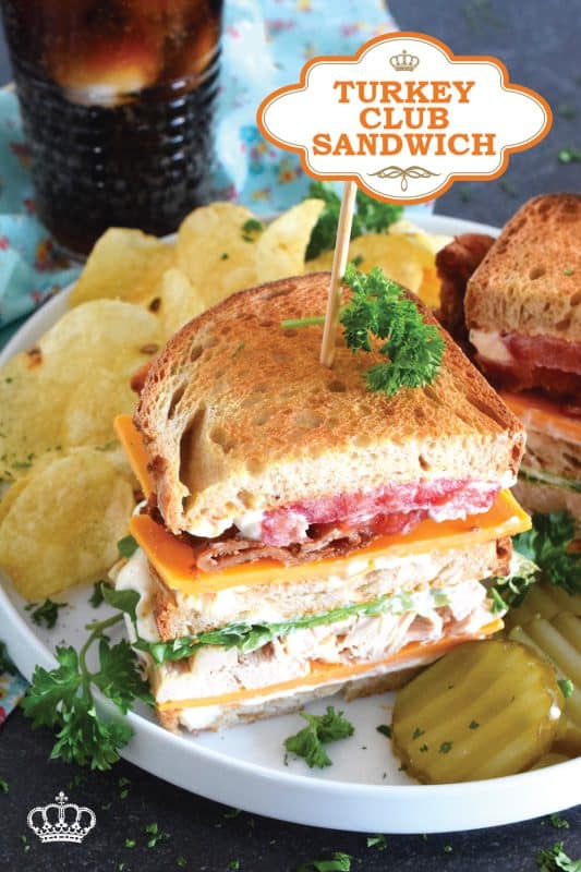 A classic restaurant-style club sandwich will never go out of style! Easily prepare these Turkey Club Sandwiches at home with leftover holiday turkey, crispy bacon slices, fresh lettuce and tomato, a good smear of mayonnaise, and some sliced sharp cheddar cheese! Everything is piled onto toasted sandwich bread and served with a side of potato chips and a pickle.  You can't beat it! #turkey #club #leftover #sandwich #clubsandwich #bacon
