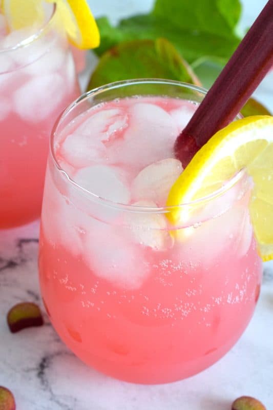 A tall glass of ice-cold rhubarb flavoured soda with a good splash of vodka is perfect for sipping on a hot summer day. Prepared with simple ingredients like sugary rhubarb syrup, vodka, and sparkling water, it’s sure to wake up your senses! When it comes to drinks suited for lounging in the backyard on a hot, summer day, nothing beats a Boozy Rhubarb Soda! #boozy #rhubarb #sparkling #soda #vodka